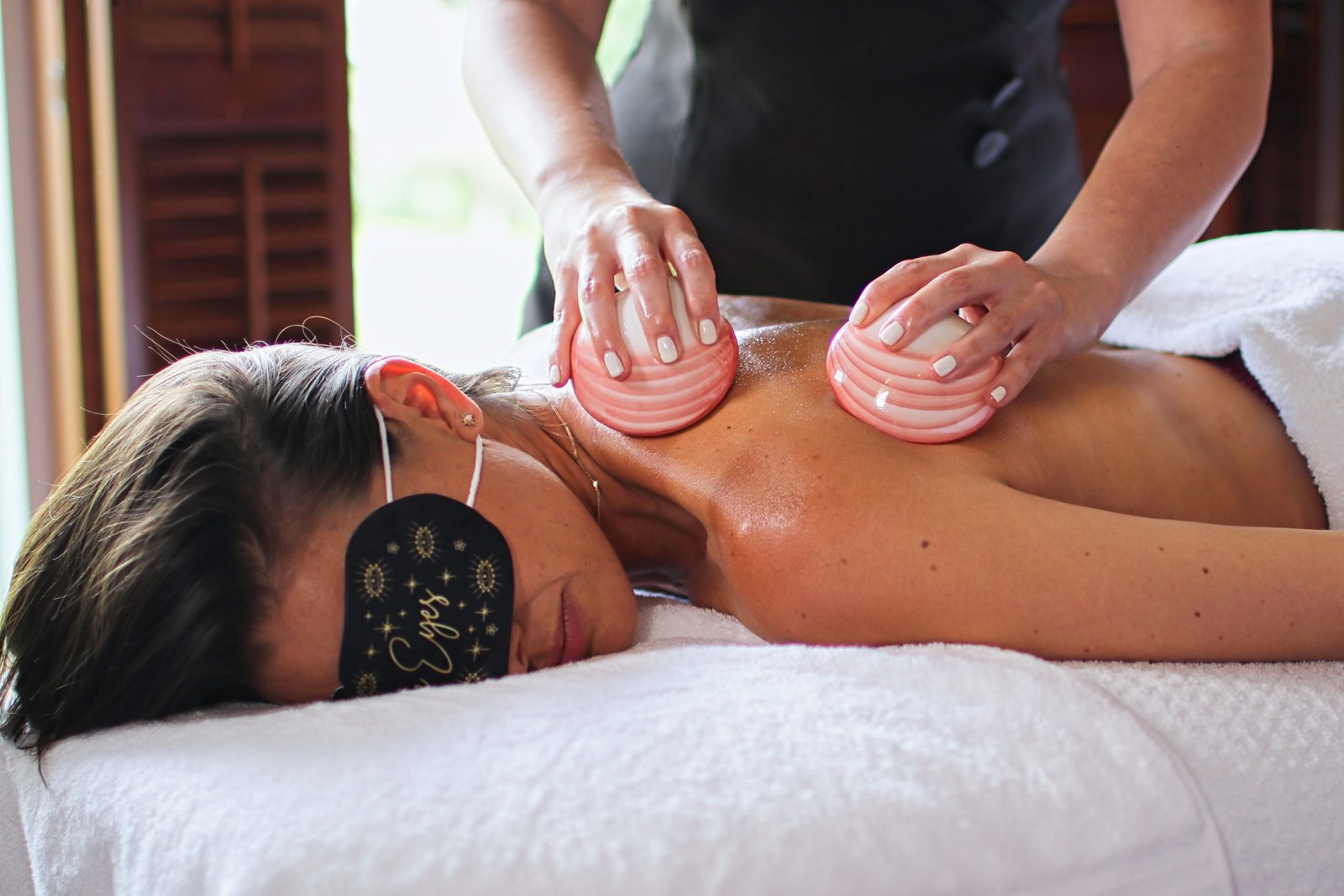 A therapist giving a back massage with warm oils